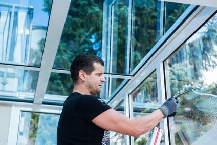 Fensterputzer reinigt Wintergarten